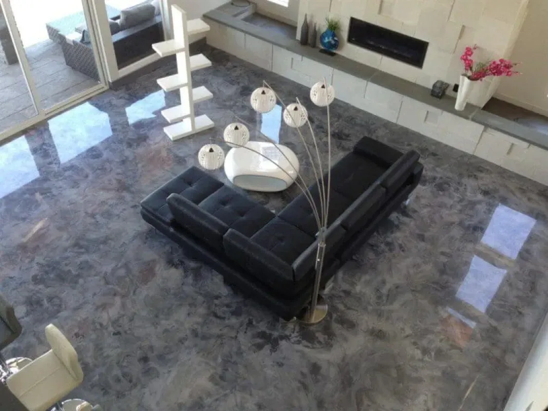 Modern living room with black sectional sofa, glass table, and floor lamp on polished marble floor