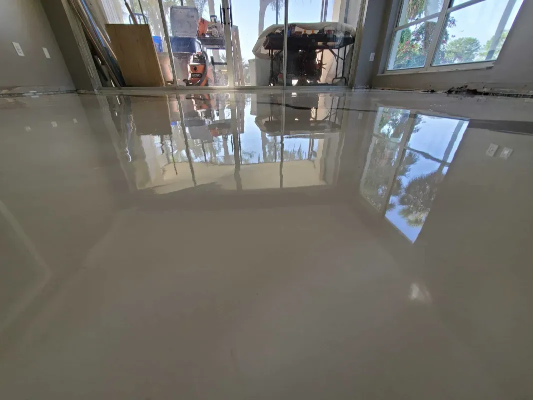 Shiny tiled floor reflecting windows and furniture in a bright indoor lobby