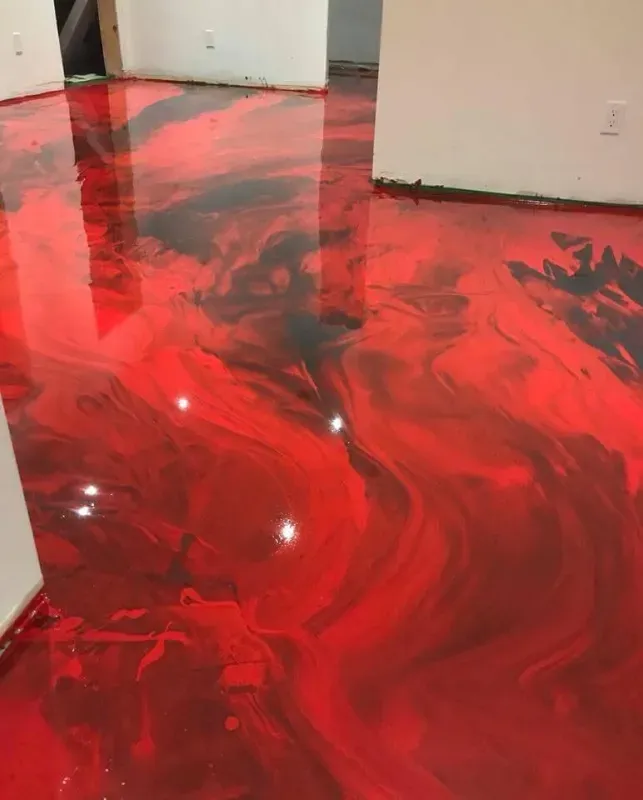 Red and black marbled epoxy floor in an empty room with white walls and doorway openings