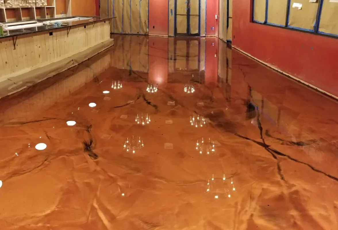 Flooded orange hallway with standing water reflecting the ceiling lights