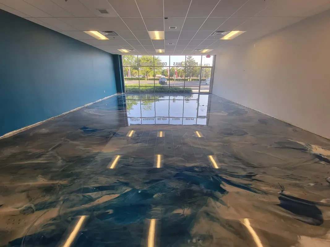 Empty modern room with glossy blue-and-white marbled floor and large windows at the far end