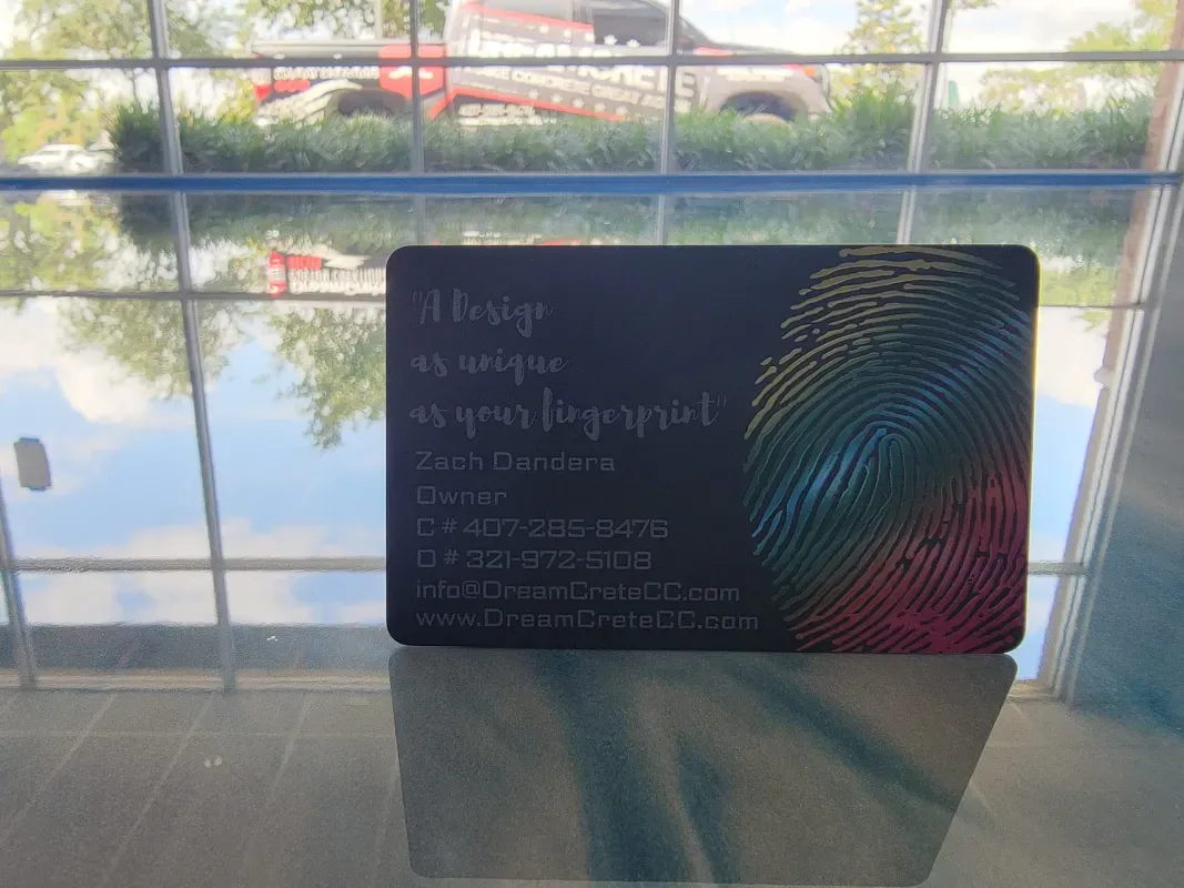 Promotional signboard on a table by a window, with colorful abstract stripes and blurred outdoor view behind it