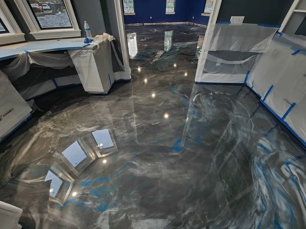 Polished gray floor reflecting lights and nearby desks in a modern workspace