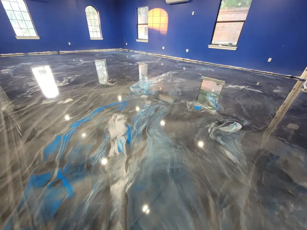Indoor pool room with blue walls and a large reflective water surface under windows.