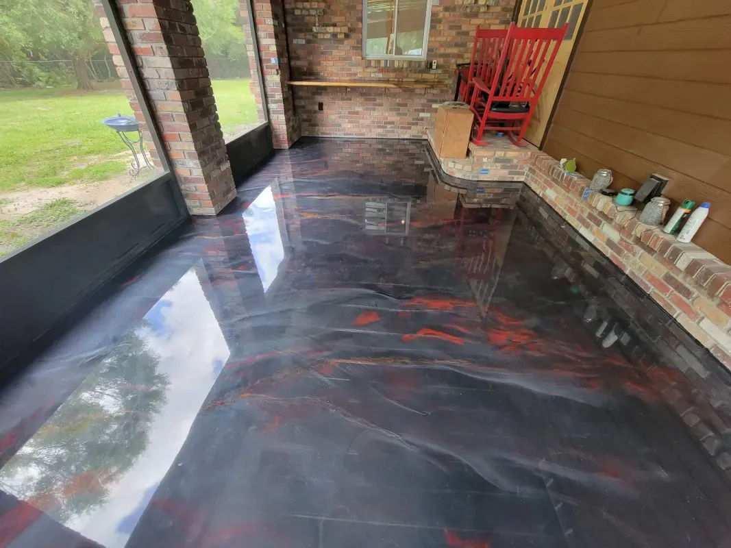 Glossy black and red concrete floor on a covered brick-and-wood porch