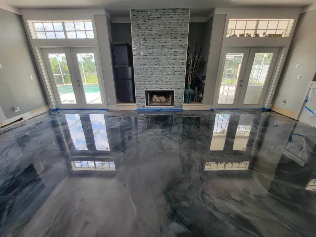 Empty living room with glossy marbled floor, large windows, and a fireplace centered on the far wall.