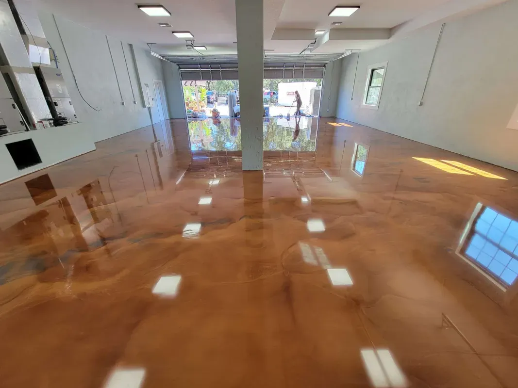 Empty room with glossy brown floor, white walls, and large windows at the far end