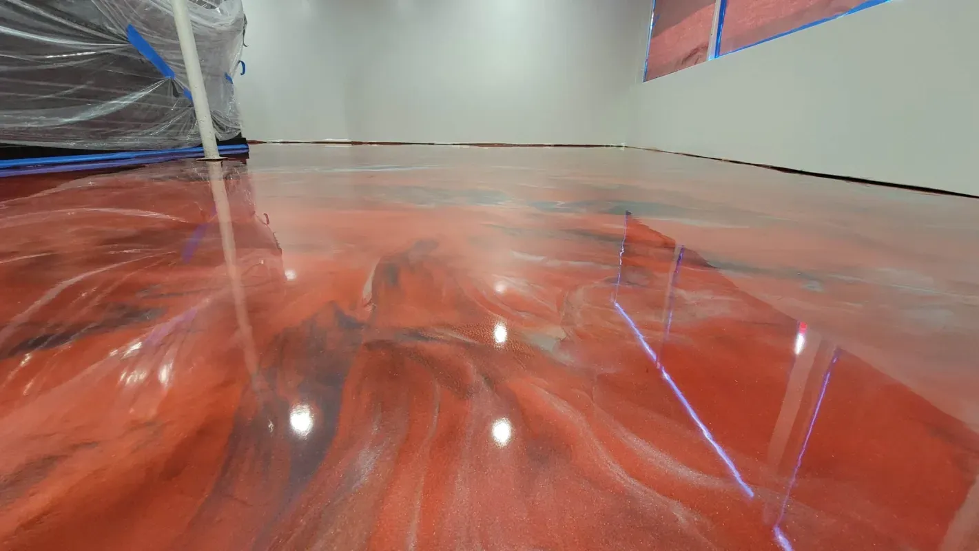 Red indoor slide or tunnel with glossy surface and bright reflections, viewed from inside the curve