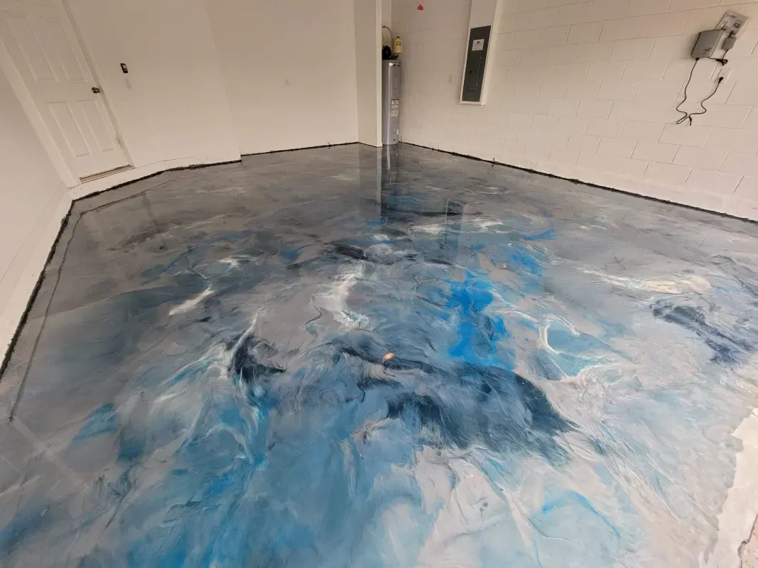 Blue-gray epoxy floor coating drying in a bare room with white walls and doors