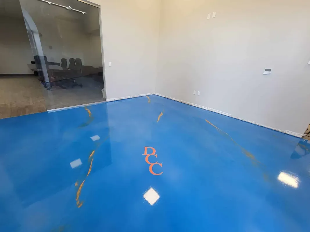 Empty room with glossy blue floor, white walls, and an open doorway to a dark adjacent space