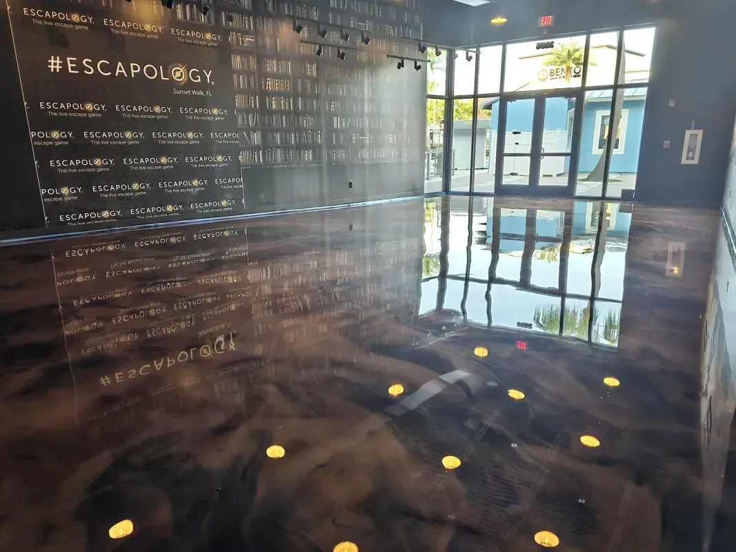 Dim museum exhibit with a wall of text and a glass doorway lit by sunlight, reflecting on the floor.