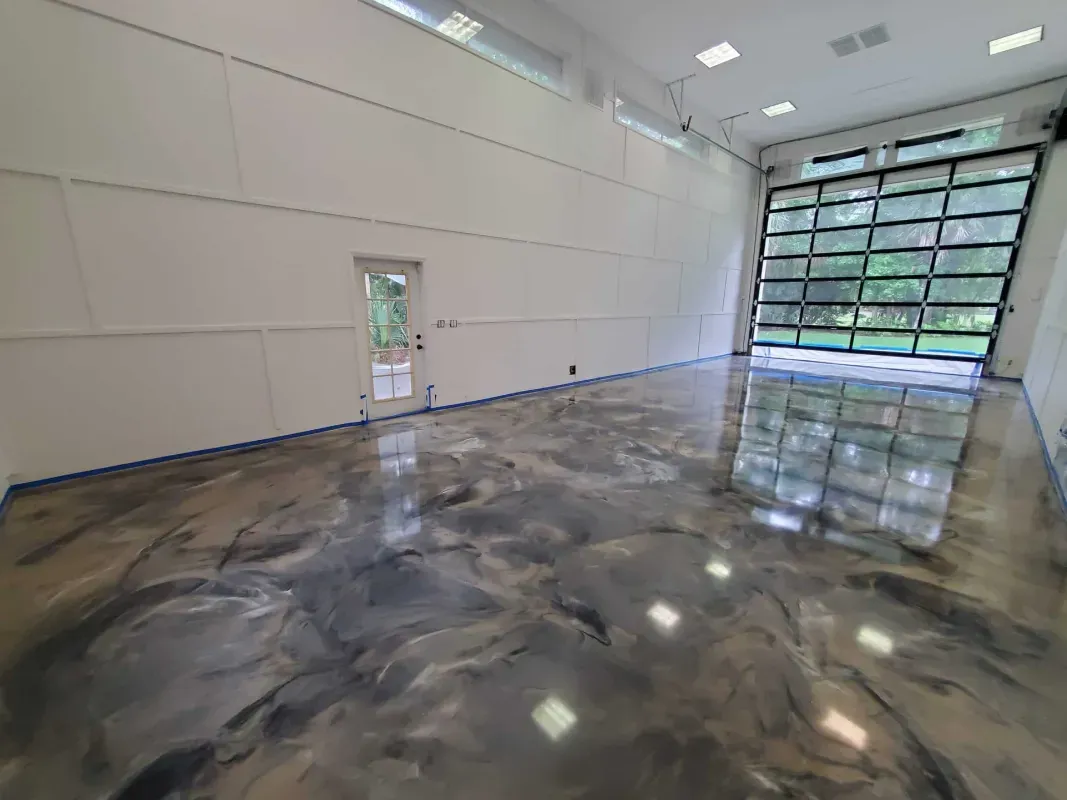 Empty modern warehouse with polished concrete floor and a large glass garage door