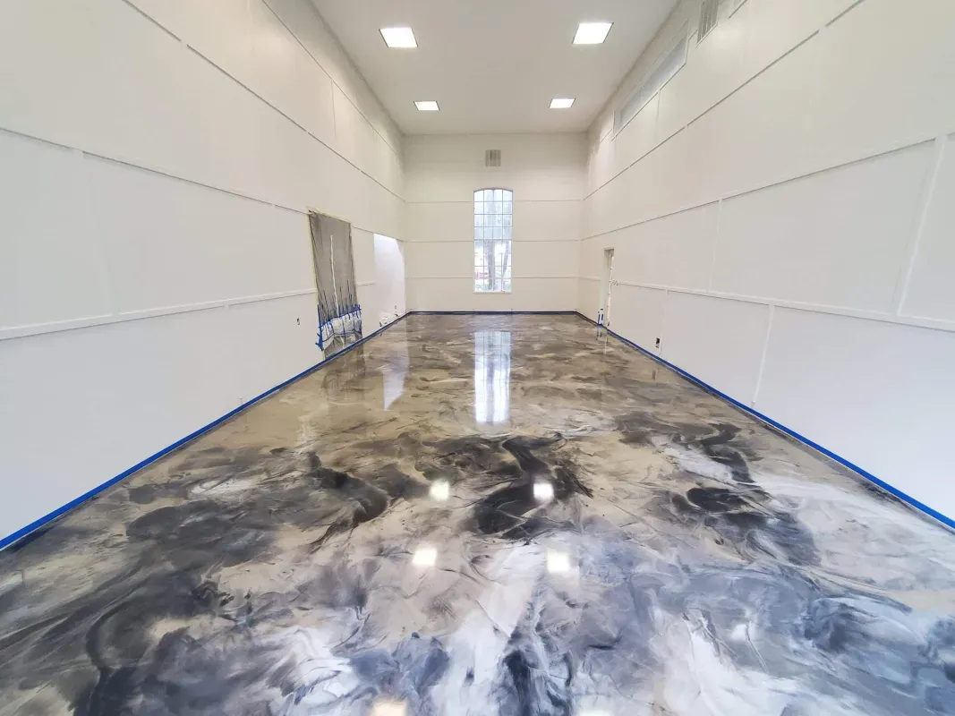 Empty white room with glossy concrete floor and tall windows at the far end.