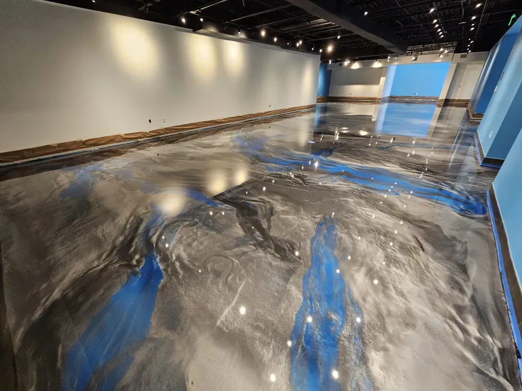 Modern art installation with a glossy black-and-blue floor in a white gallery room