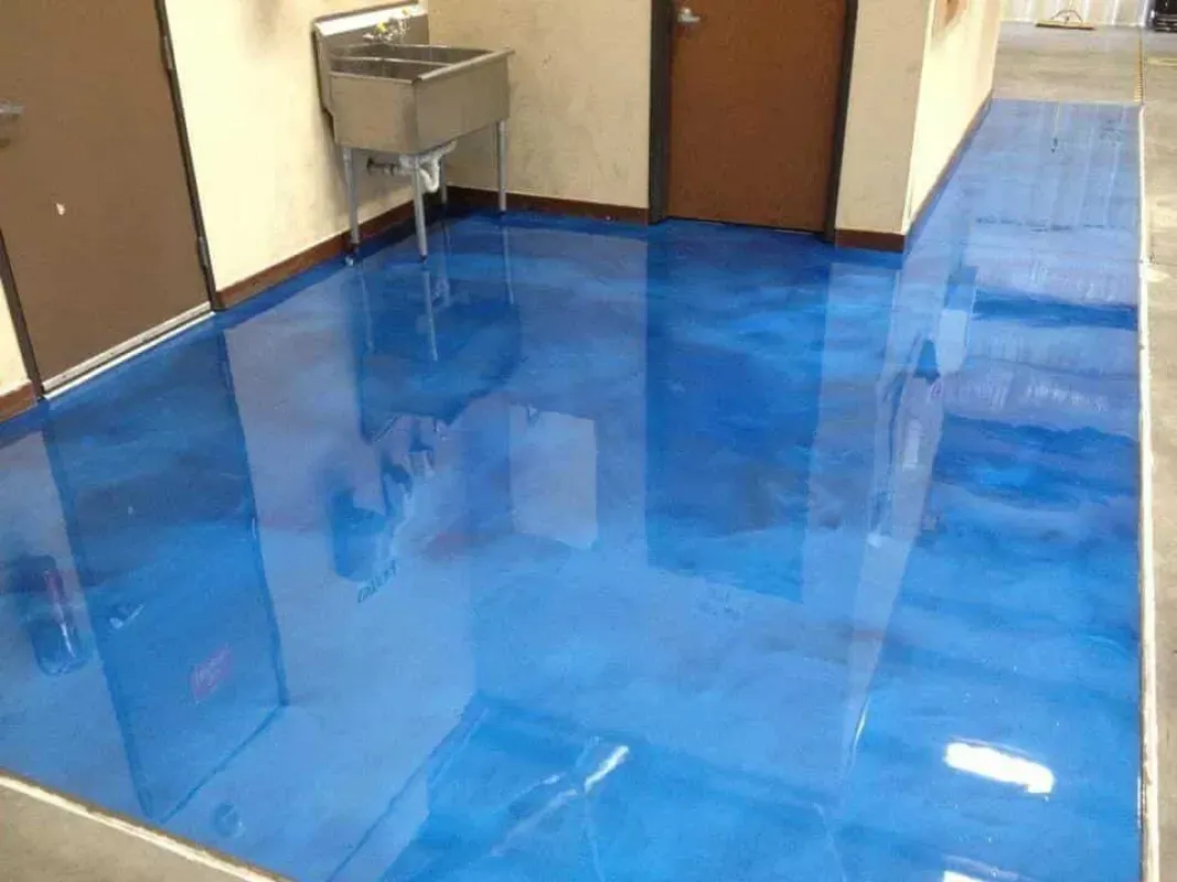 Shiny blue floor in a hallway with brown doors and a small sink against the wall