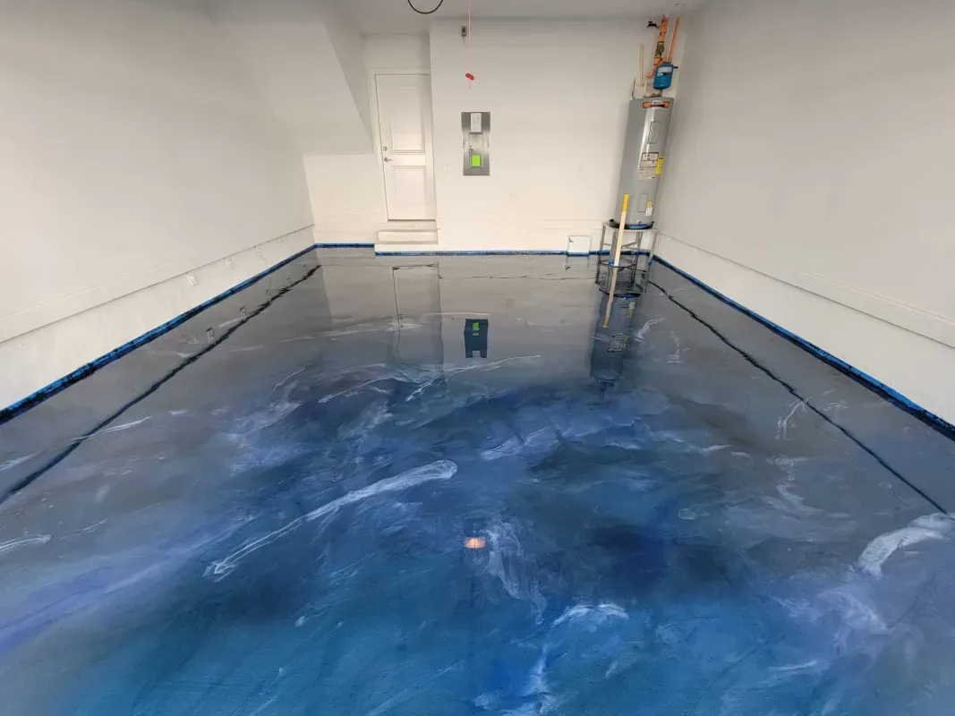 Flooded white room with blue water covering the floor and pipes along the right wall.