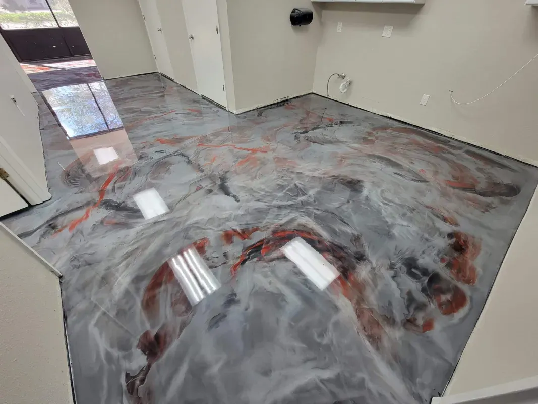Office floor coated with gray-white liquid swirls and debris near a doorway and wall.