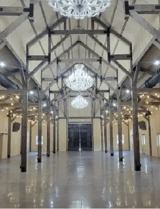 Grand hall with exposed beams, chandelier lights, and a polished reflective floor