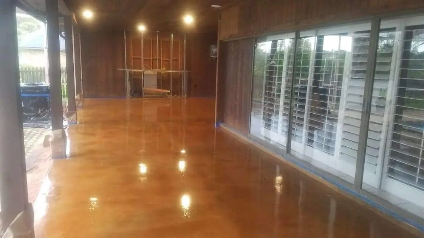 Empty polished room with wooden ceiling and large windows along one wall