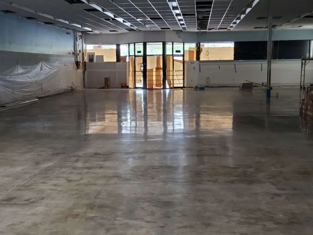 Empty commercial interior with polished concrete floor and glass entrance doors