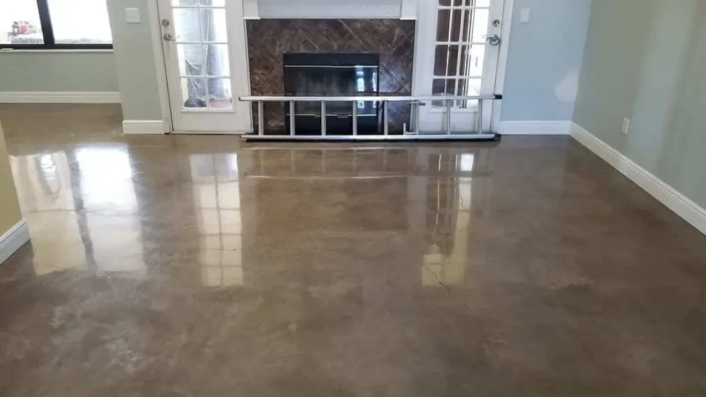 Empty living room with polished concrete floor and a fireplace with glass doors