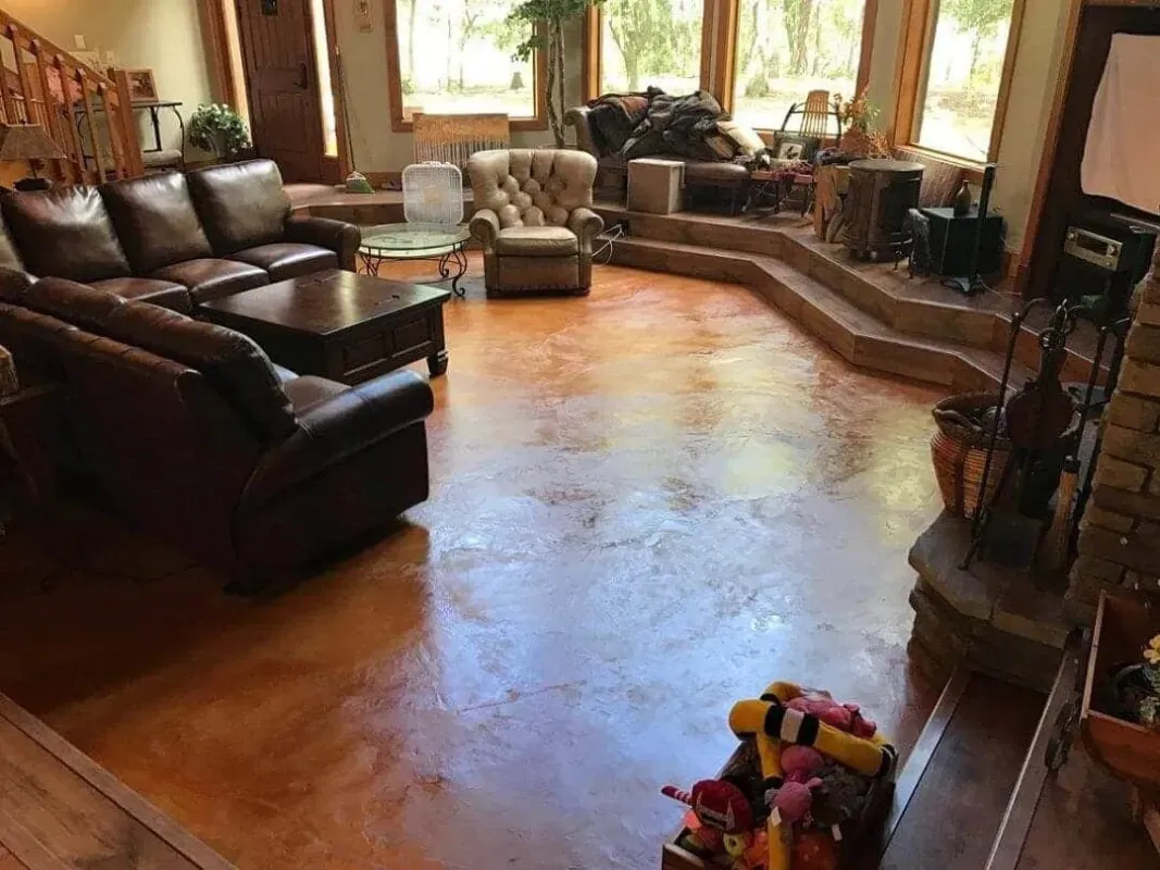 Living room with leather sofas, fireplace, windows, and colorful toy on wooden floor