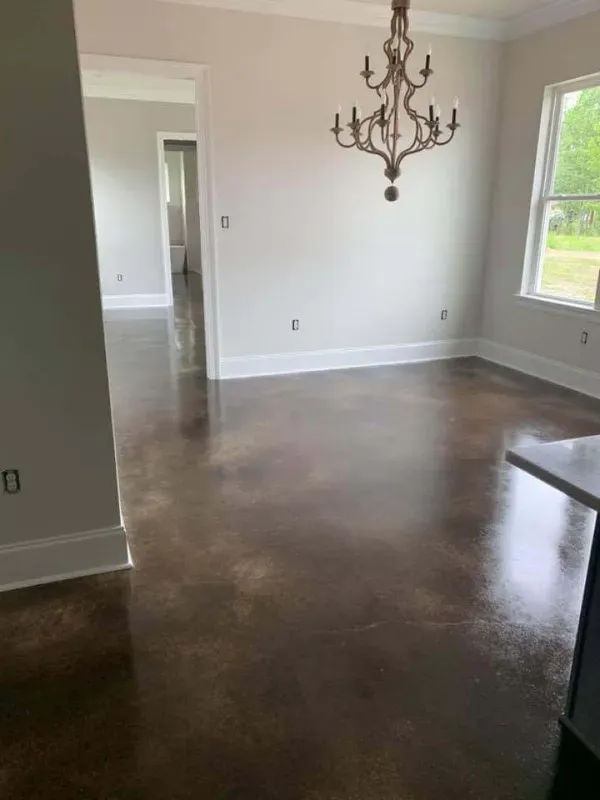 Empty dining room with dark floors, white walls, a chandelier, and a window view outside.