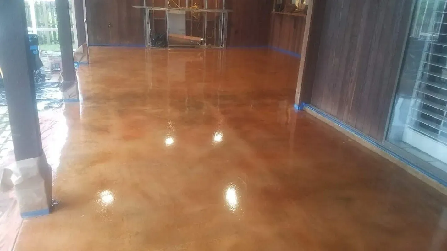 Shiny wooden floor in an empty room with windows and reflections of overhead lights