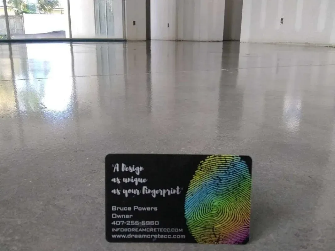 Business card on a polished floor, featuring a colorful fingerprint design and white text.