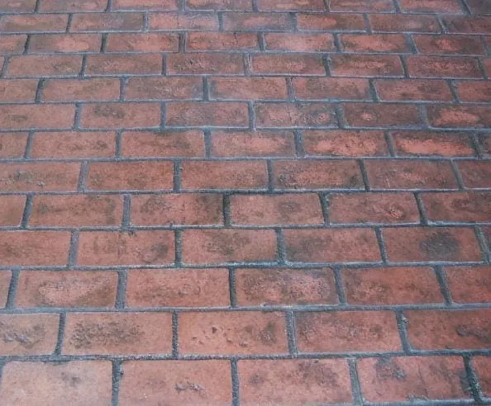 Close-up of a reddish-brown brick pavement with gray mortar lines