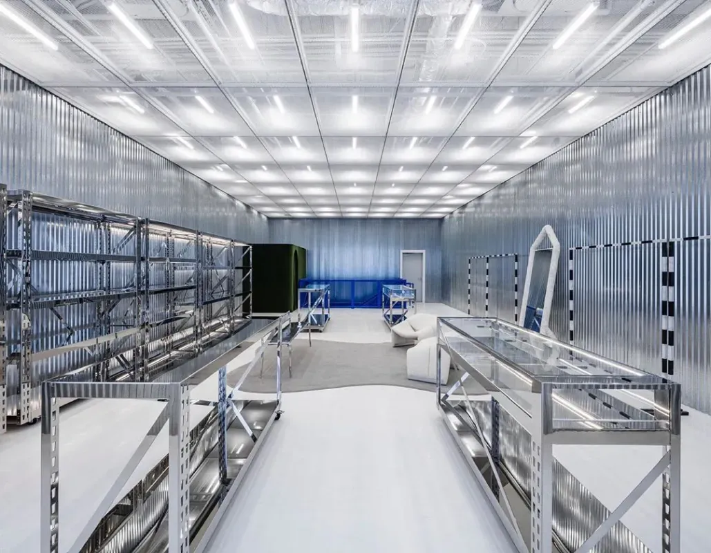 Bright modern laboratory with metal racks, white flooring, and a blue equipment panel