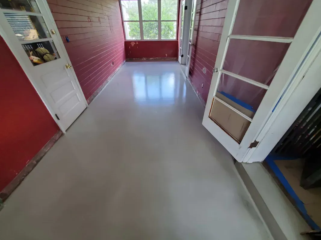 Empty hallway with red walls, white trim, and large windows at the end.