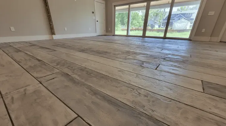 Empty room with wide-plank wood flooring and sliding glass doors opening to a yard