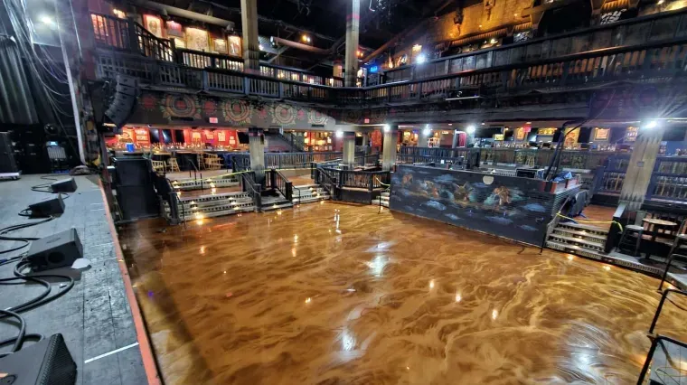 Empty polished dance floor in a dimly lit multi-level nightclub or theater interior