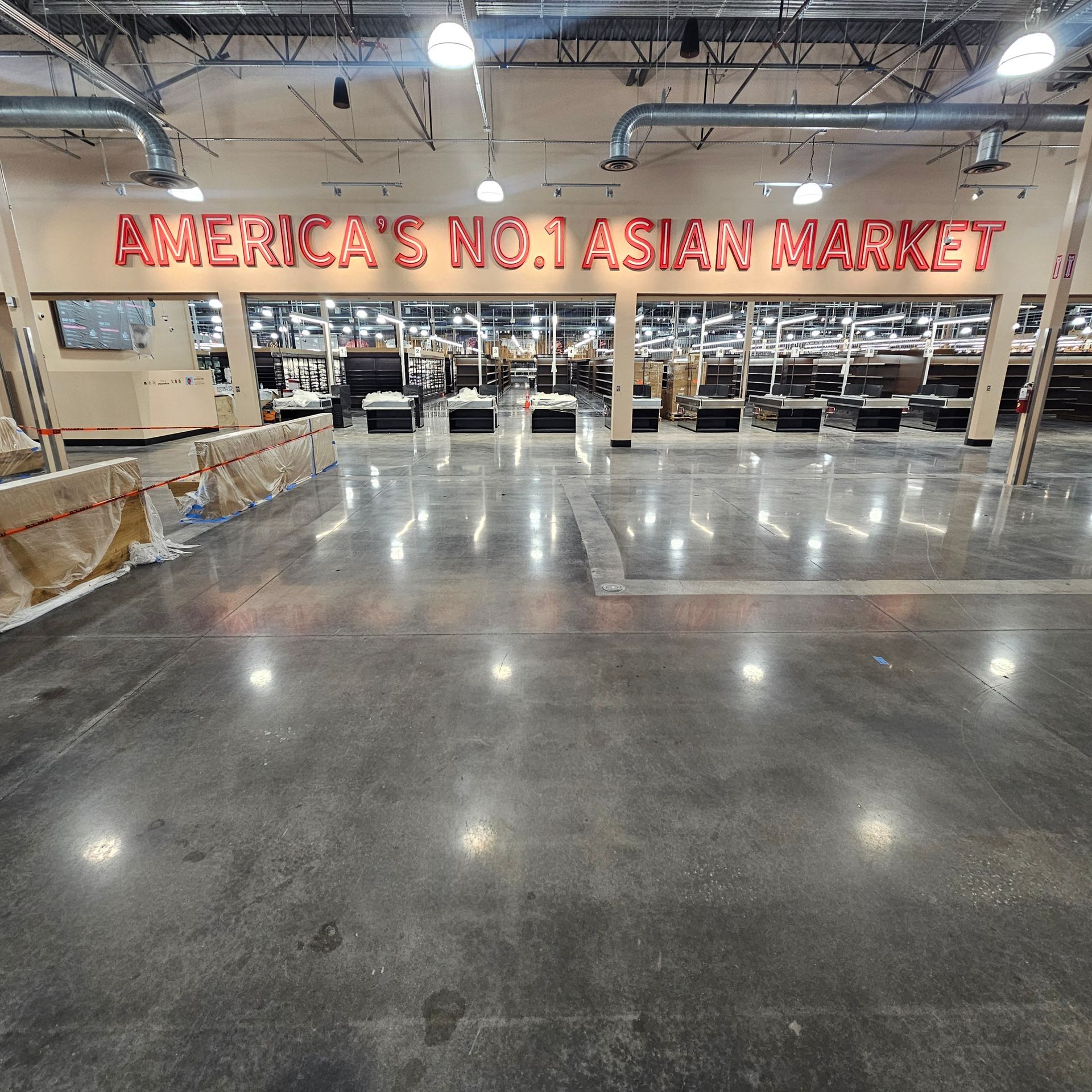 Empty Asian market interior with polished floor and glowing red sign reading “AMERICA’S NO.1 ASIAN MARKET”
