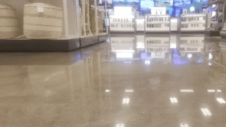 Store aisle with polished floor, display shelves, and bright lights reflected in the distance.
