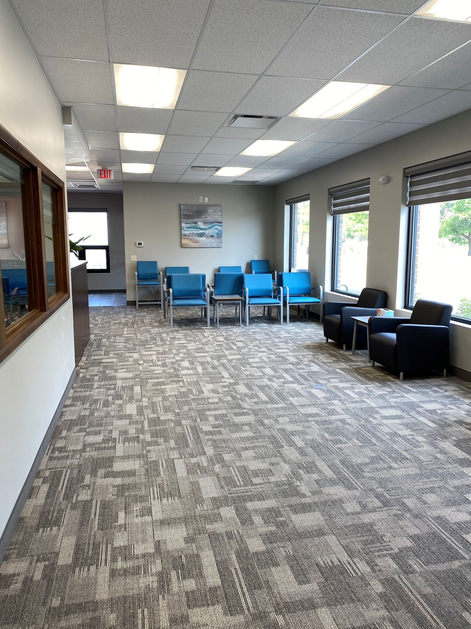 A large waiting room with a lot of chairs and tables.