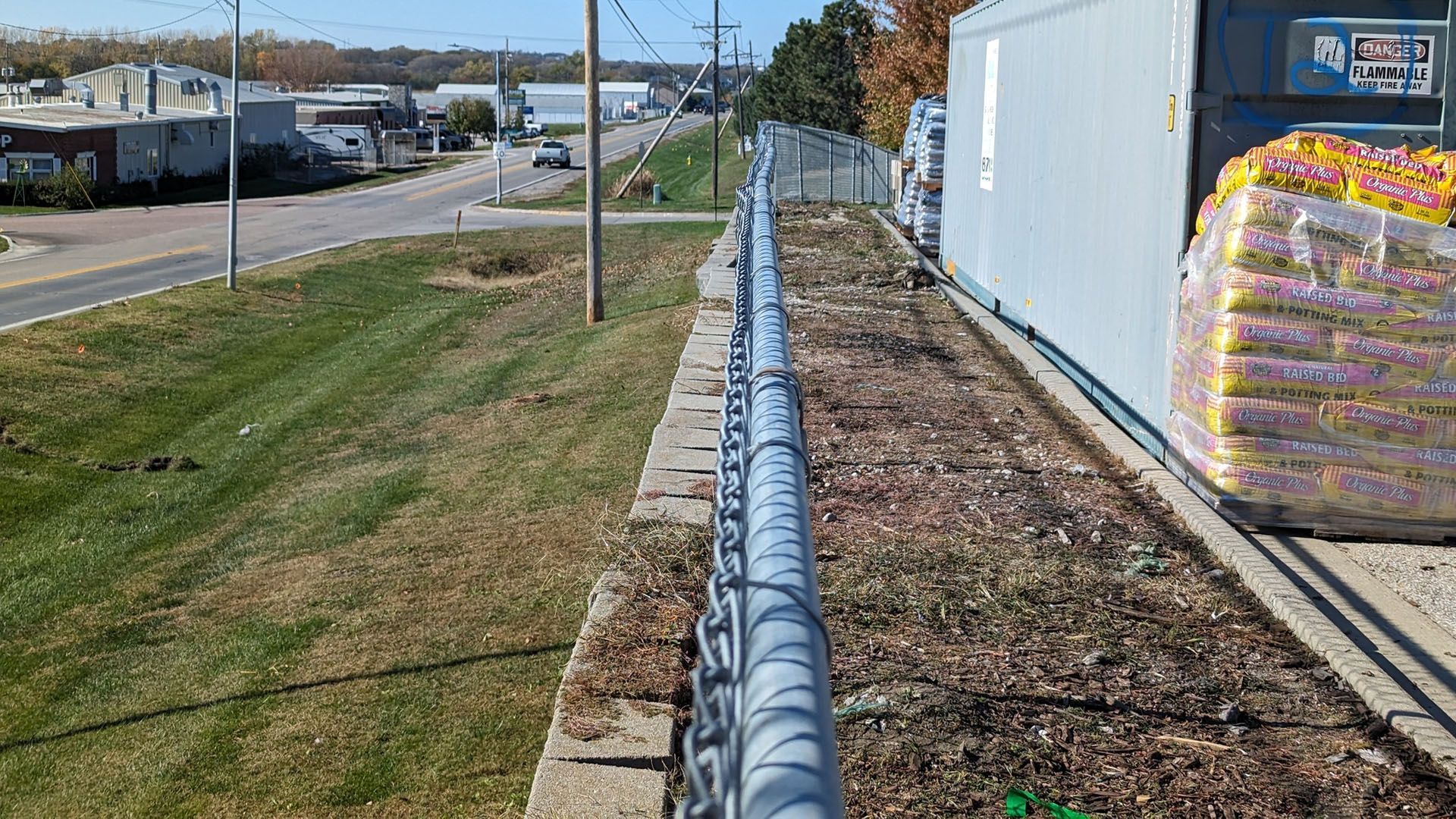 A chain link fence is along the side of a road.