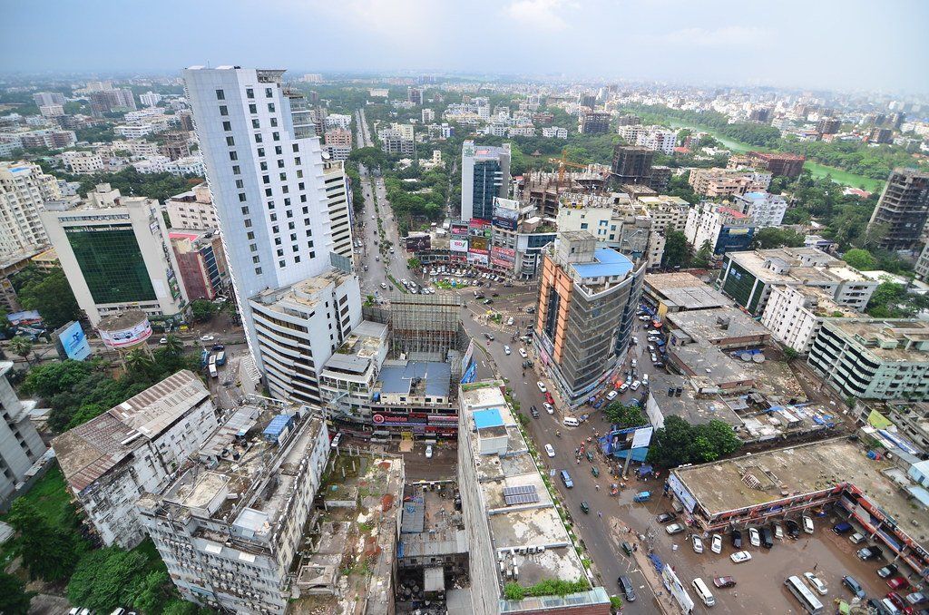 Aerial view of Dhaka city, Bangladesh, with skyscrapers and busy streets. Buildings of various heights and styles, overcast sky.