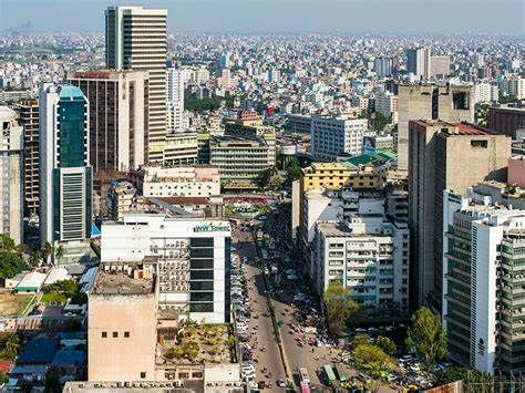 Cityscape of Dhaka, Bangladesh, with many high-rise buildings and a busy street below. Overcast, day time.