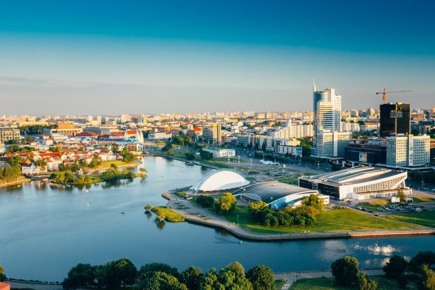 Aerial view of Minsk, Belarus. A modern city with a river, buildings, and blue sky.