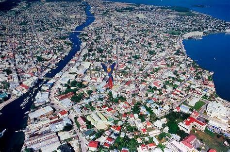 Aerial view of Belize City, Belize, showing buildings and streets along a river and coastline.