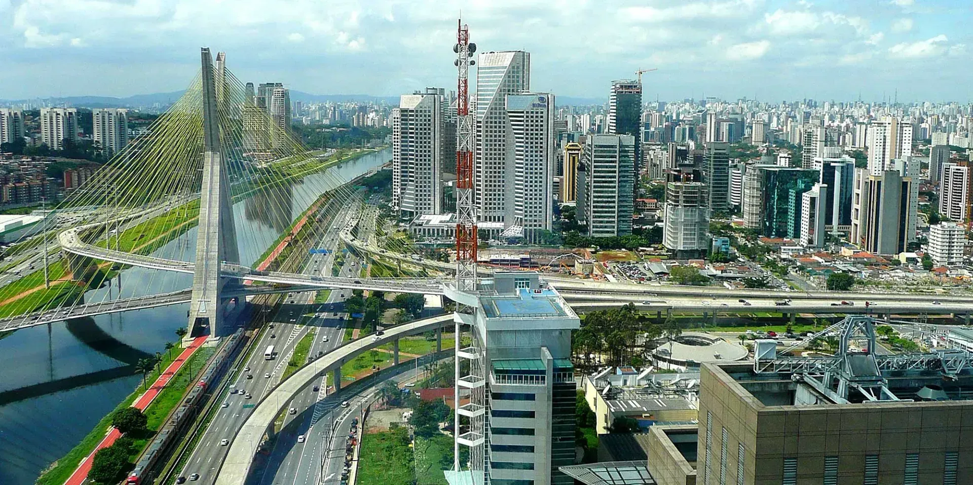 Panoramic view of São Paulo, Brazil, featuring the Estaiada Bridge, a river, highways, and a dense cityscape.