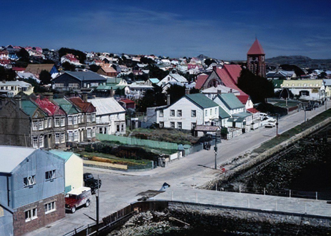 View of Stanley, Falkland Islands. Colorful houses line the streets, a church with a red roof is visible.
