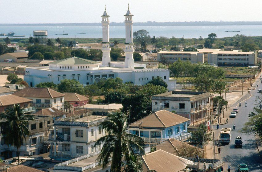 Mosque with twin white minarets overlooking a city street and the sea in Banjul, Gambia.