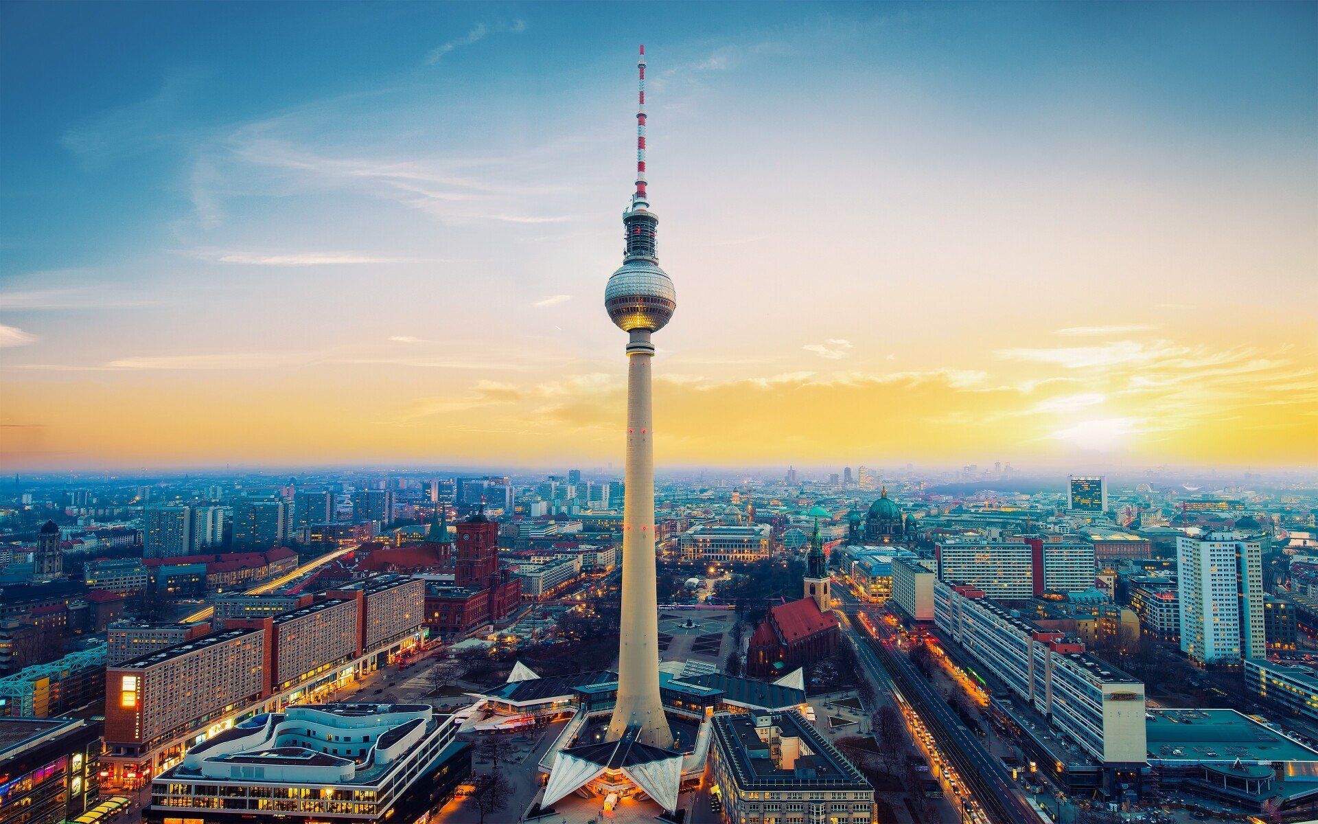 Berlin skyline with the Television Tower at sunset, a prominent structure against a colorful sky.
