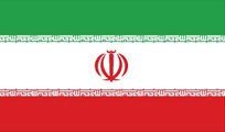 The Iranian flag, horizontally striped green, white, and red, with a red emblem in the center and Arabic script along the edges.