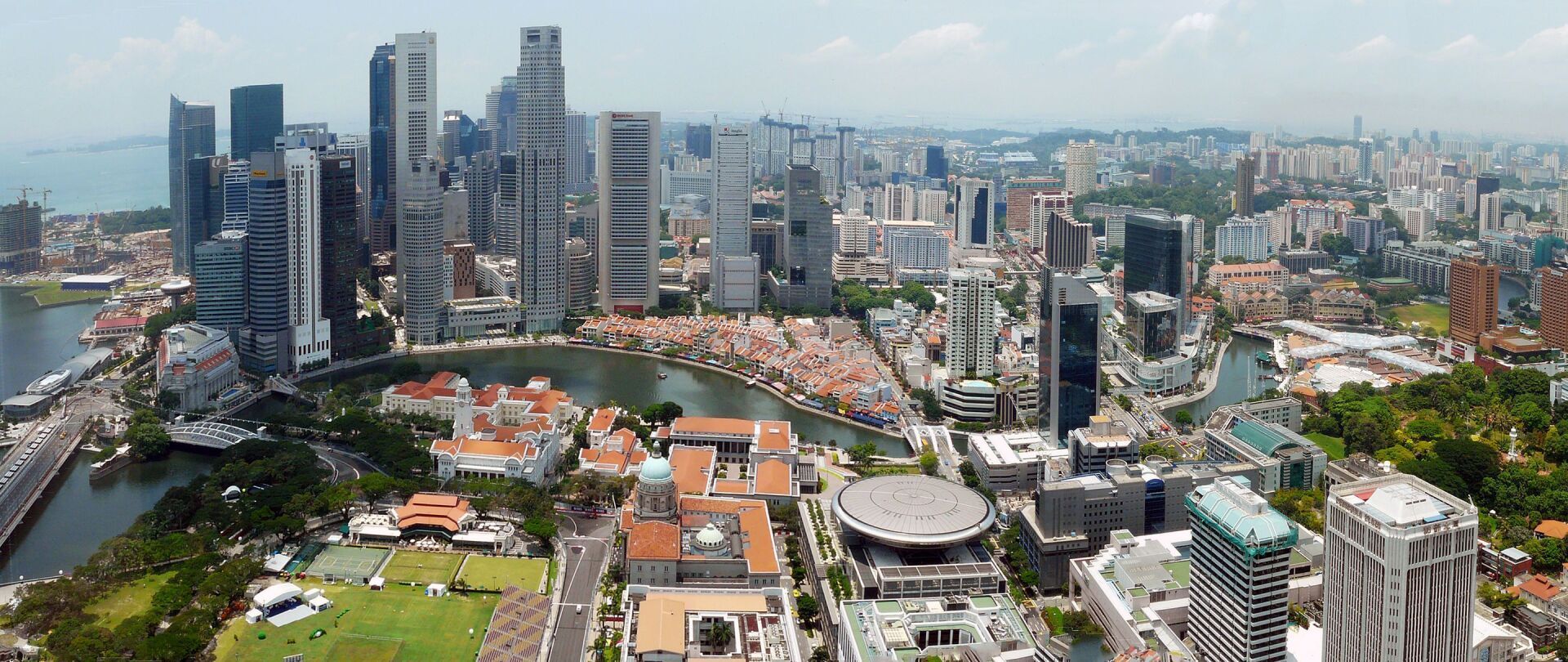 Aerial view of a city skyline in Singapore, with tall skyscrapers and waterfront buildings.