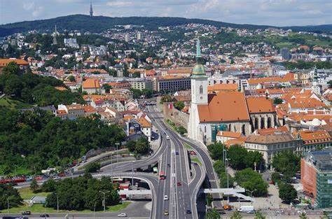Cityscape with a highway intersection, St. Martin's Cathedral with a white tower, and buildings nestled on a hillside.