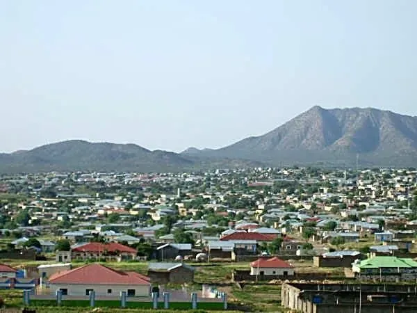 Townscape of Hargeisa, Somaliland, with buildings and a mountain range in the background under a clear sky.